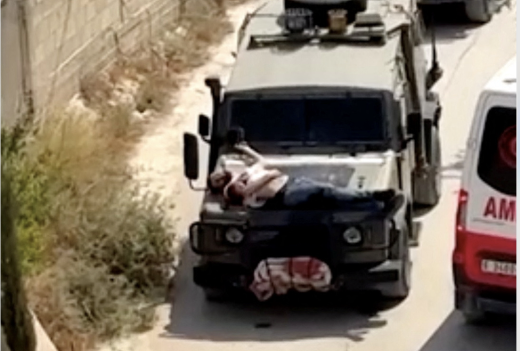 قوات إسرائيلية تقيد فلسطينيا جريحا فوق مقدمة عربة عسكرية.. والجيش يعلق