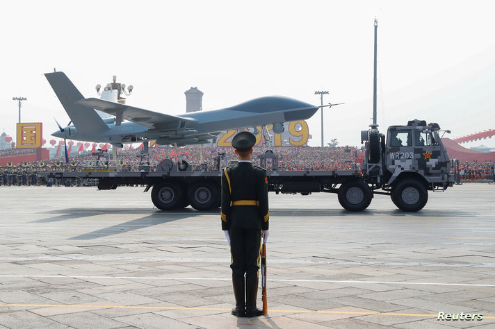 A military vehicle carrying an unmanned aerial vehicle (UVA) travels past Tiananmen Square during the military parade marking…
