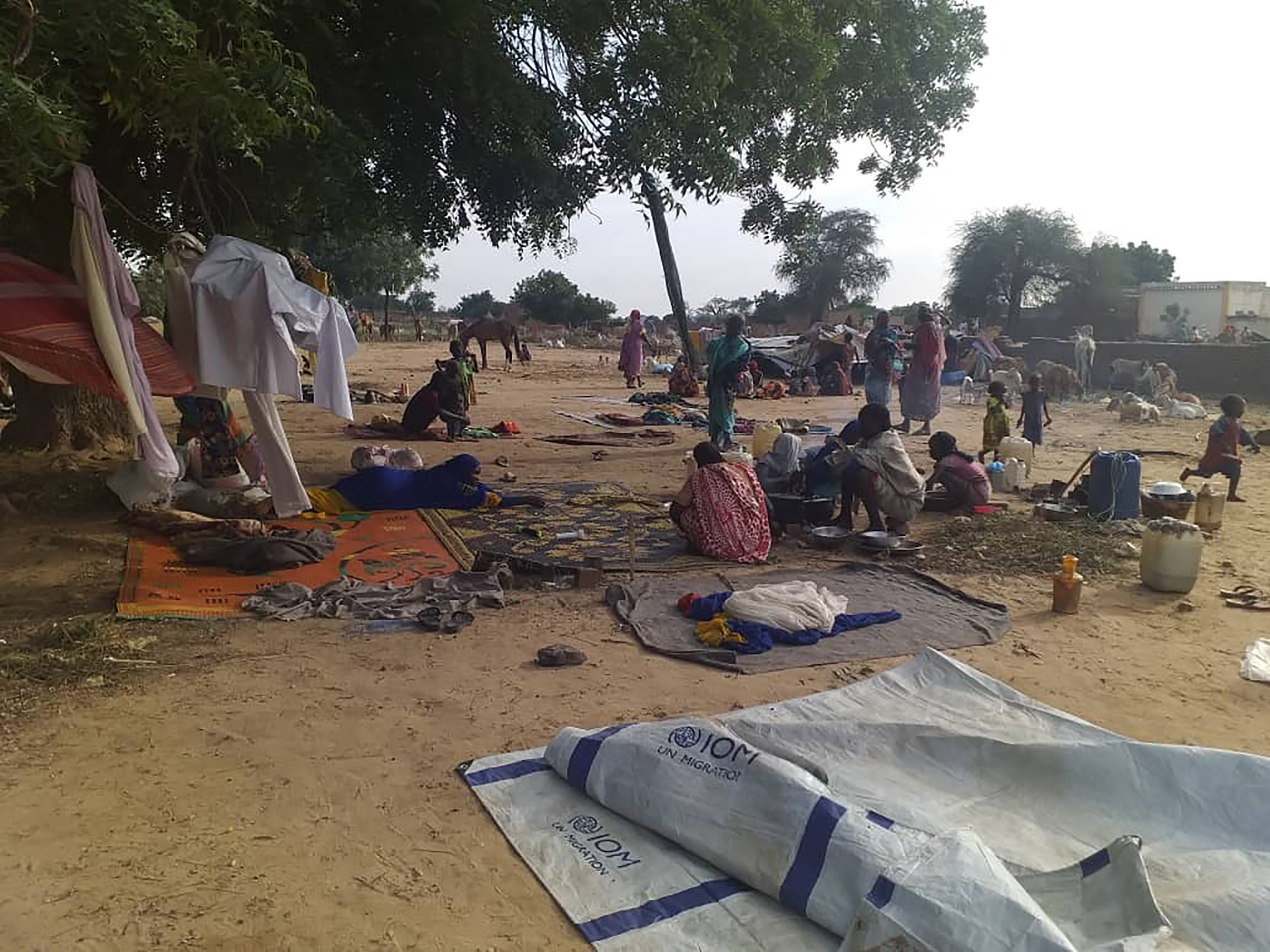 FILE - Residents displaced from a surge of violent attacks squat on blankets and in hastily made tents in the village of…