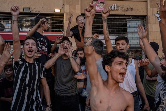 ساحة الشهداء، في بيروت، 28 سبتمبر 2024. “هذه الصورة المذهلة للفرح لها قصة خاصة. عندما أُعلن عن وفاة نصر الله، أصيبت الشوارع اللبنانية بالصدمة. كنت حينها في ساحة الشهداء، صامتًا، عندما سمعت أصواتًا عالية قادمة من المقاهي المحيطة. وكانت شاشة التلفزيون قد بثت كلمة أرشيفية لحسن نصر الله، ولكن مع لافتة “مباشرة”، مما ضلّل أهل هذا المقهى، الذين ظنوا أن زعيم حزب الله لم يمت. » </i> “> <img decoding=