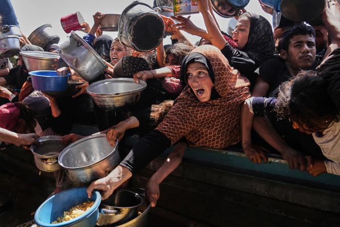 يقاتل الفلسطينيون من أجل الحصول على الطعام المقدم في المطبخ المجتمعي في خان يونيس ، في جنوب قطاع غزة ، يوم الجمعة 9 مايو 2025.