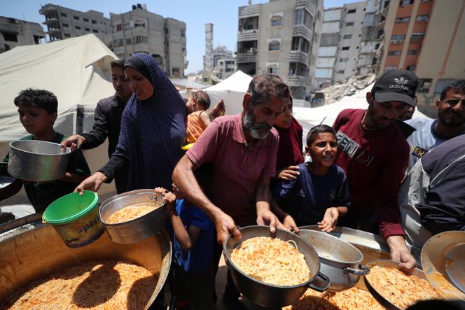ينتظر الفلسطينيون تلقي الطعام الذي أعده المأكولات الخيرية في غزة في 21 يونيو 2025.
