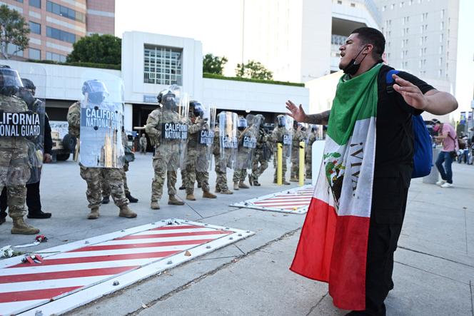 متظاهر أمام الجنود من الحرس الوطني في كاليفورنيا في لوس أنجلوس في 12 يونيو 2025.