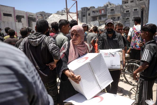 يحمل الفلسطينيون بطاقات مساعدة وزعتها الهلال الأحمر ، في غزة ، في 26 يونيو 2025. 