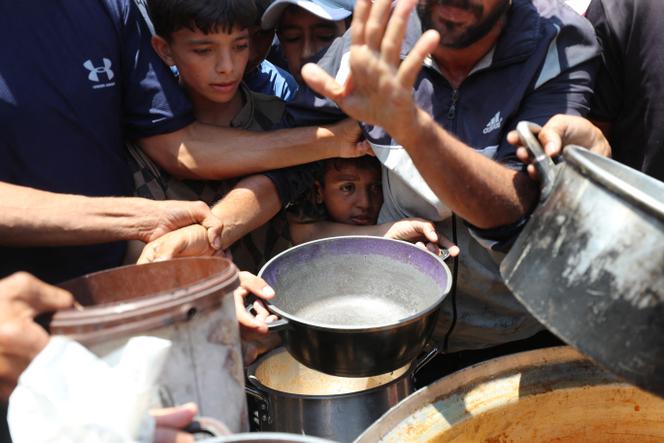 ينتظر الفلسطينيون تلقي الطعام الذي أعده المأكولات الخيرية في غزة في 21 يونيو 2025.
