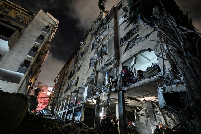 يتدخل رجال الإنقاذ في مبنى متأثر بضربة إيرانية في وسط إسرائيل في 15 يونيو 2025.