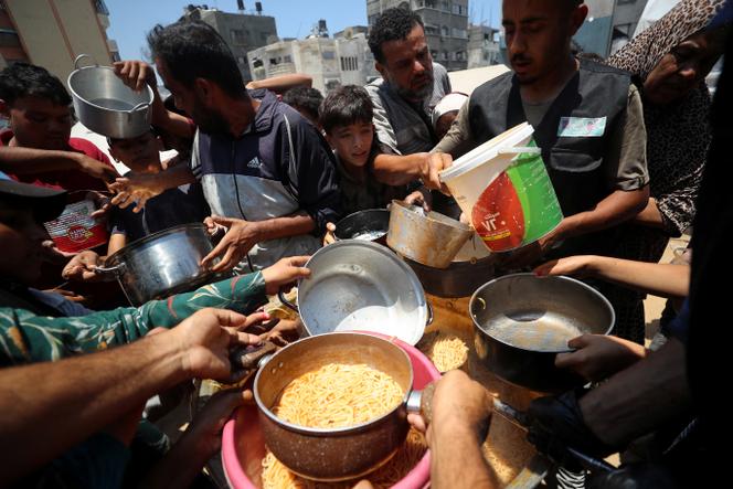 ينتظر الفلسطينيون تلقي الطعام الذي أعده المأكولات الخيرية في غزة في 21 يونيو 2025.