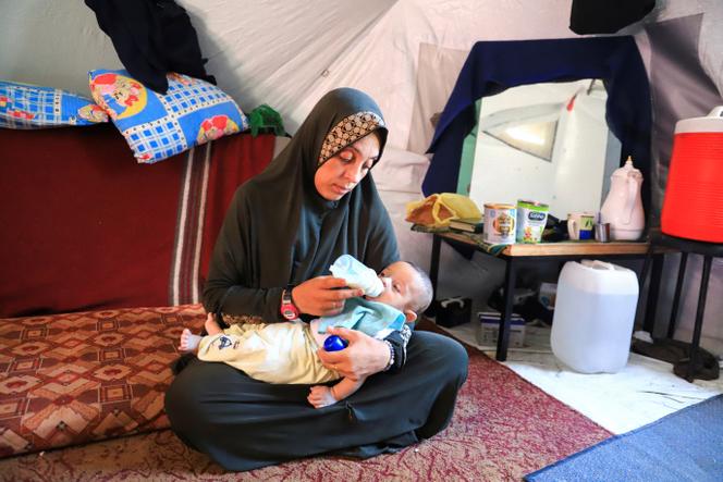 فلسطينية مع واحدة من توأمها لمدة شهرين ، بينما تكافح من أجل العثور على الحليب الطبيعي في سياق نقص مستمر في غزة في 25 يونيو 2025.