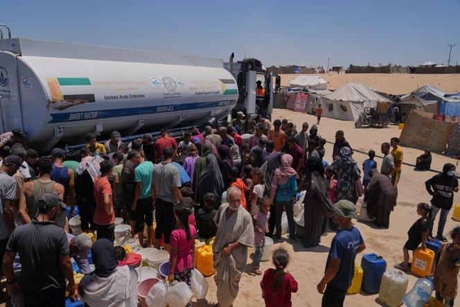 يتجمع الفلسطينيون النازحون لجمع المياه من شاحنة ناقلة في معسكر في خان يونيس ، في جنوب قطاع غزة ، السبت 19 يوليو 2025.
