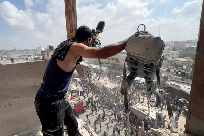 رجل يحمل المعدات التي يستخدمها المصور الفلسطيني حوتسام الماسري ، الذي كان بموجب عقد مع رويترز ، في الموقع الذي قُتل فيه مع صحفيين ومدنيين آخرين خلال إضرابات في مستشفى ناصر في خان يونز ، 25 أغسطس 2025. 