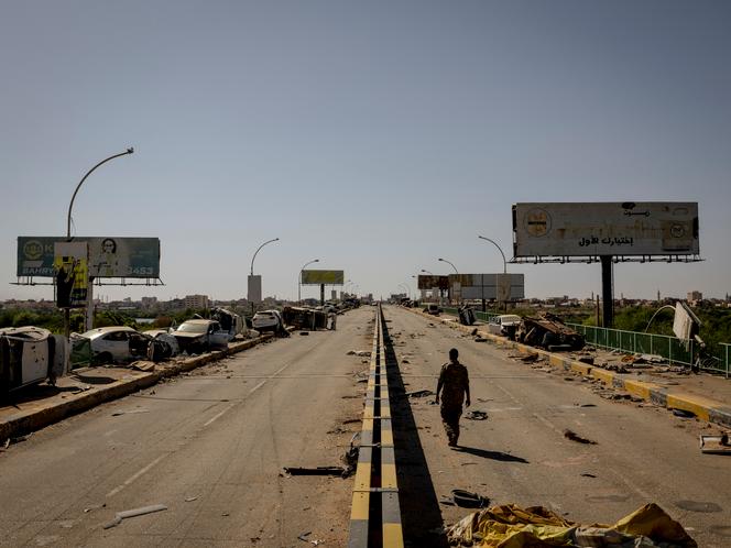 يسير الرائد أشرف إلباشير ، ضابط الجيش السوداني ، على طول جسر شامبات في خروم نورد ، الذي تم تدميره.