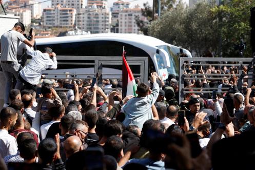 أشخاص يتجمعون للترحيب بالأسرى الفلسطينيين المفرج عنهم أثناء مغادرتهم أحد السجون الإسرائيلية، في رام الله، 13 أكتوبر، 2025.