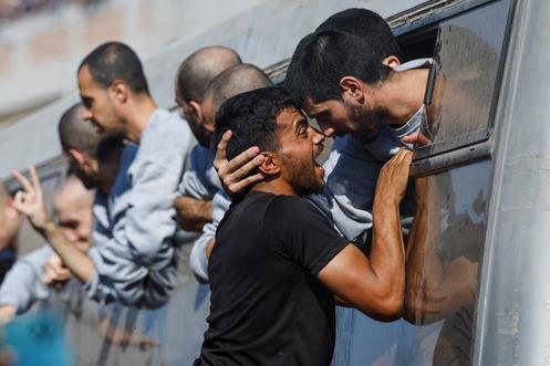 رجل يحيي أسيرًا فلسطينيًا أفرجت عنه إسرائيل في خان يونس، 13 أكتوبر، 2025.