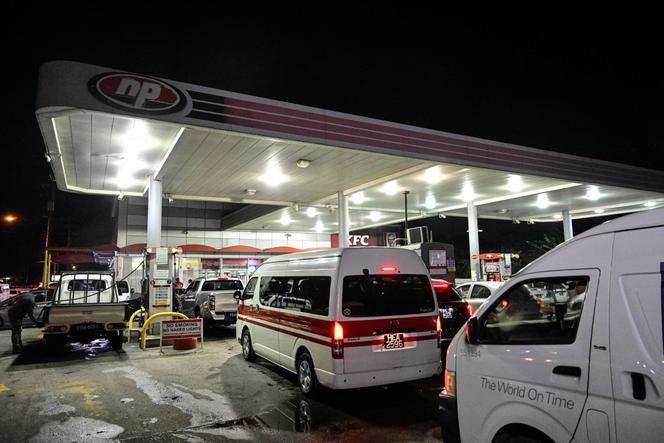 أشخاص يتزودون بالوقود في محطة وقود في بورت أوف سبين في 31 أكتوبر 2025. 