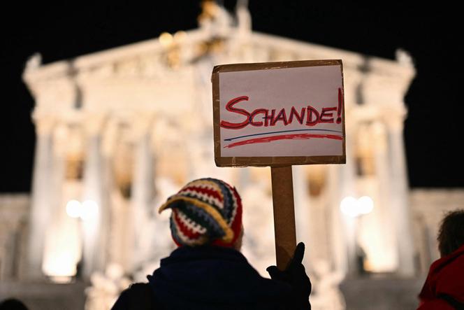 متظاهر يحمل لافتة “العار” أمام البرلمان، حيث يقام تكريم للسياسي النازي فرانز دينغوفر، في فيينا، 11 نوفمبر 2025.