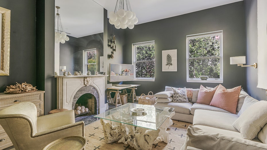 تحتوي غرفة المعيشة على مدفأة كبيرة وثريا.