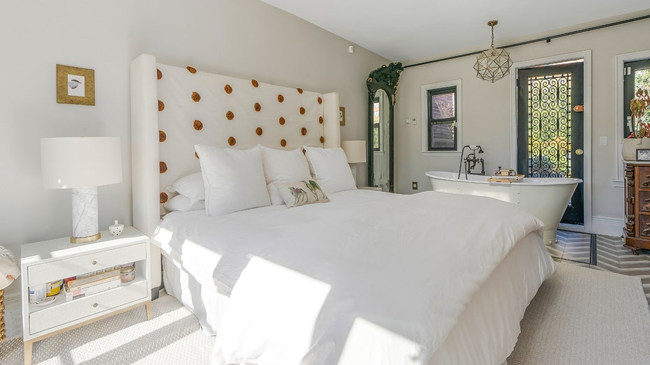 تحتوي غرفة النوم الأساسية على حوض استحمام قائم بذاته بجانب السرير.