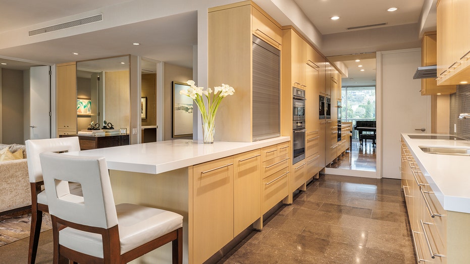 يتميز مطبخ المطبخ بجزيرة لتناول الطعام وخزائن خشبية.