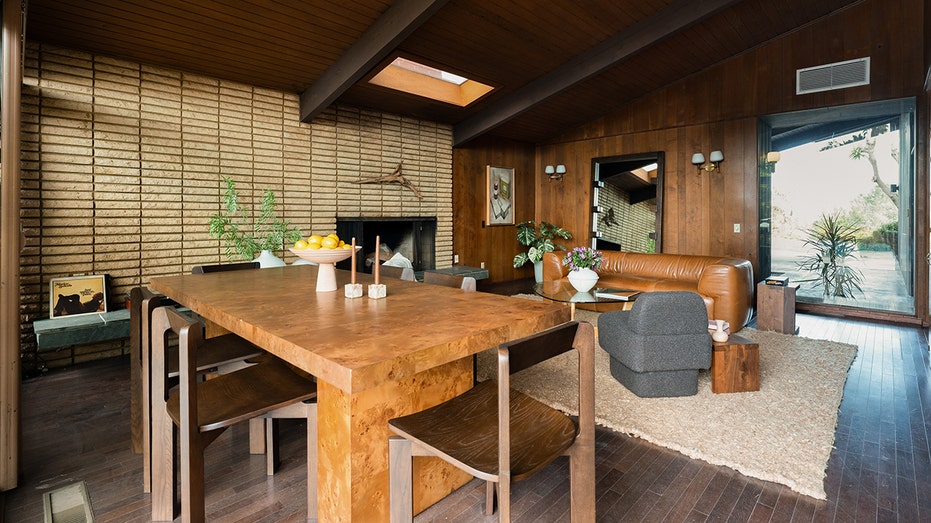 يحتوي المنزل أيضًا على غرفة مشتركة للمعيشة وتناول الطعام مع كوة ومدفأة.