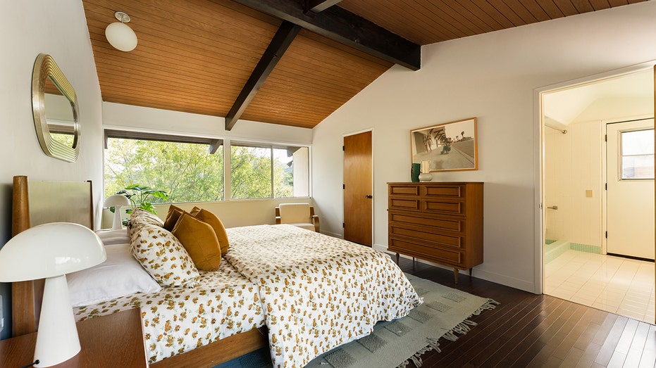 تتميز غرفة النوم الرئيسية بنافذة كبيرة تطل على المساحات الخضراء المحيطة.