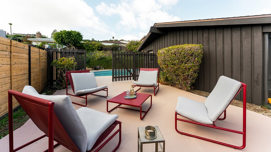 يمكن العثور على منطقة جلوس في زاوية الفناء الخلفي.