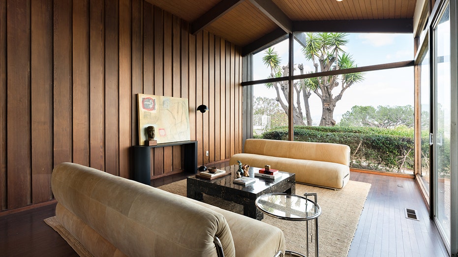 غرفة جلوس ذات نوافذ ممتدة من الأرض حتى السقف.