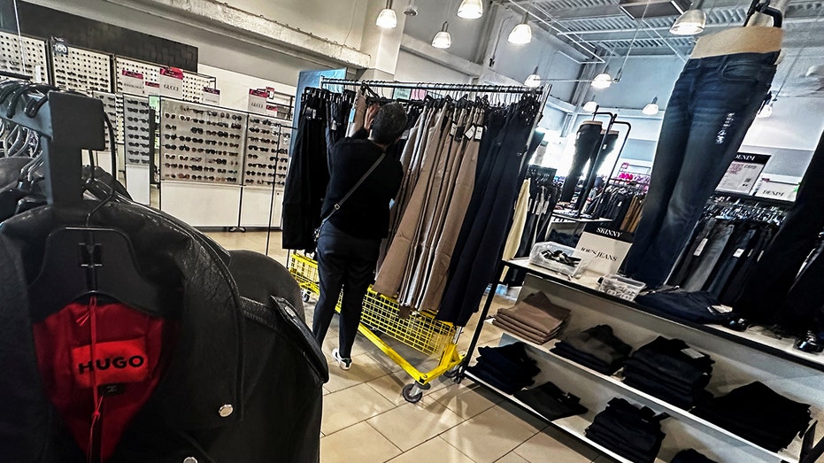 امرأة تتسوق داخل متجر Saks OFF 5TH متعدد الأقسام في ويستبري، نيويورك