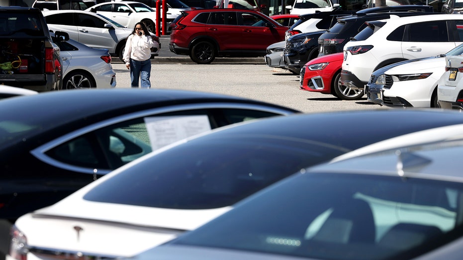 امرأة تمشي في ساحة انتظار السيارات في كولفر سيتي.