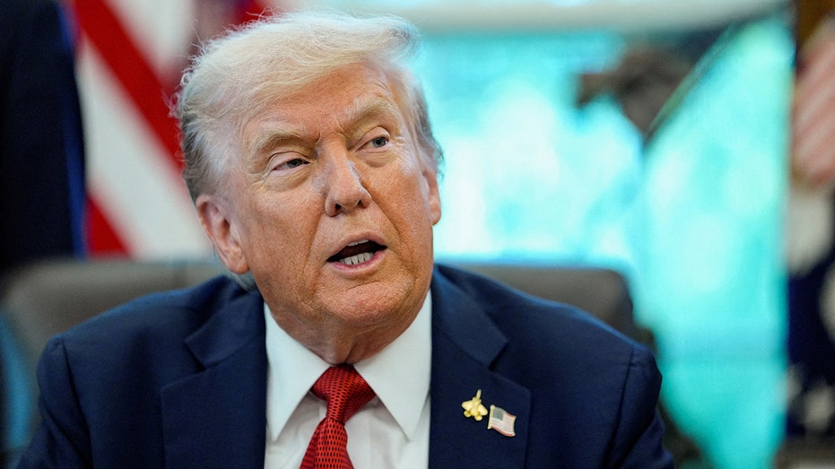 دونالد ترامب يرتدي بدلة داكنة وربطة عنق حمراء أثناء حديثه من مكتب Resolute في المكتب البيضاوي بالبيت الأبيض