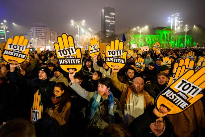 متظاهرون يحملون لافتات كتب عليها “الكل من أجل العدالة” خلال مظاهرة أمام مقر الحكومة الرومانية للمطالبة بإصلاح النظام القضائي، في بوخارست، 12 ديسمبر 2025.