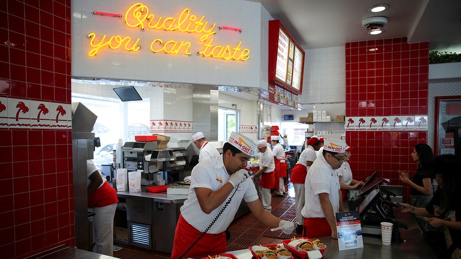 عمال يخدمون العملاء في منفذ In-N-Out Burger في لوس أنجلوس