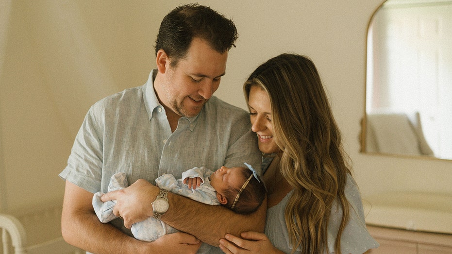 السيد والسيدة كوبيك يحملان ابنتهما حديثة الولادة.