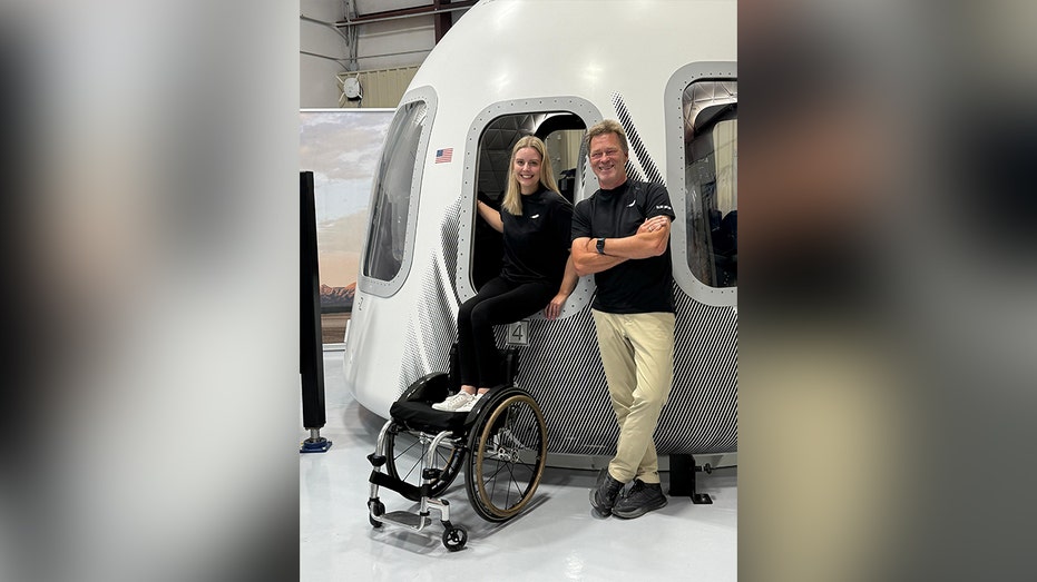 امرأة ورجل يلتقطان صورة خارج حجرة الإطلاق الفضائية في المنشأة