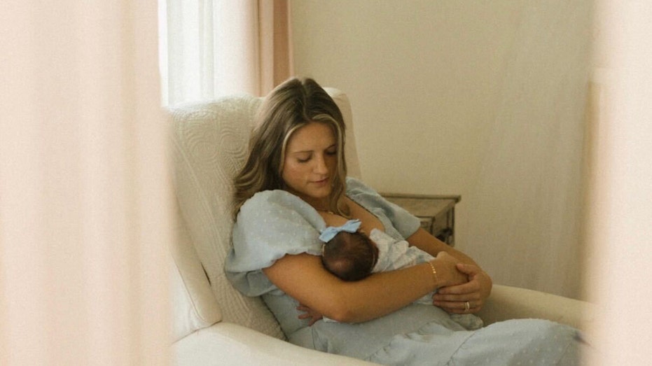 أريس كوبيك يحمل ابنته حديثة الولادة