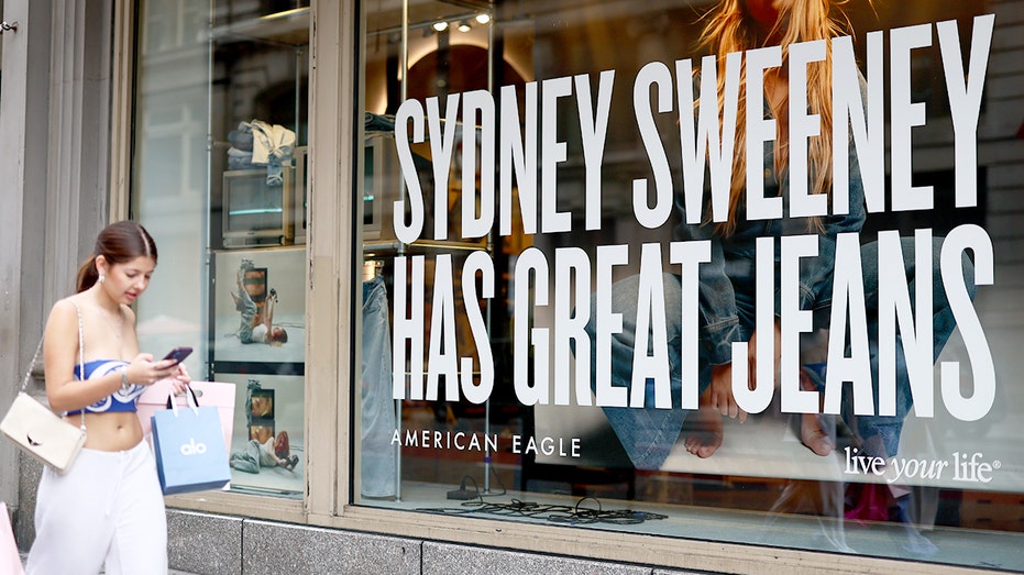 امرأة تمشي بجانب إعلان أمريكان إيجل الذي يظهر فيه سيدني سويني