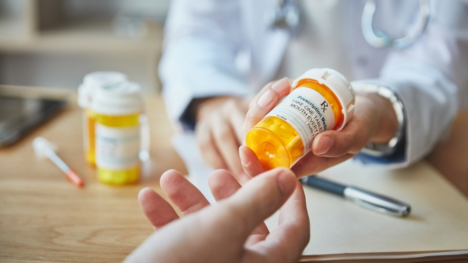 صيدلي يسلم مريضه زجاجة من الدواء.