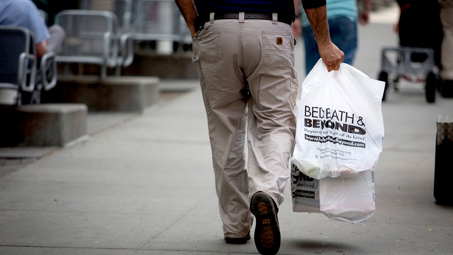 أحد العملاء يحمل أكياس التسوق بعد الخروج من موقع Bed Bath & Beyond Inc. في نيويورك، الولايات المتحدة، يوم الثلاثاء 9 أبريل 2013.