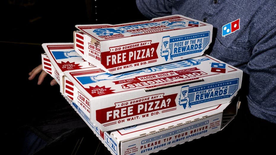 عامل دومينوز يحمل البيتزا