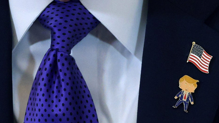 دبوس طية صدر السترة بالعلم الأمريكي و "ترامب سعيد" دبوس على بدلة ترامب