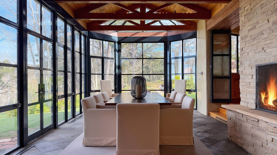 تحتوي غرفة الطعام على طاولة في غرفة بها زجاج في كل مكان.