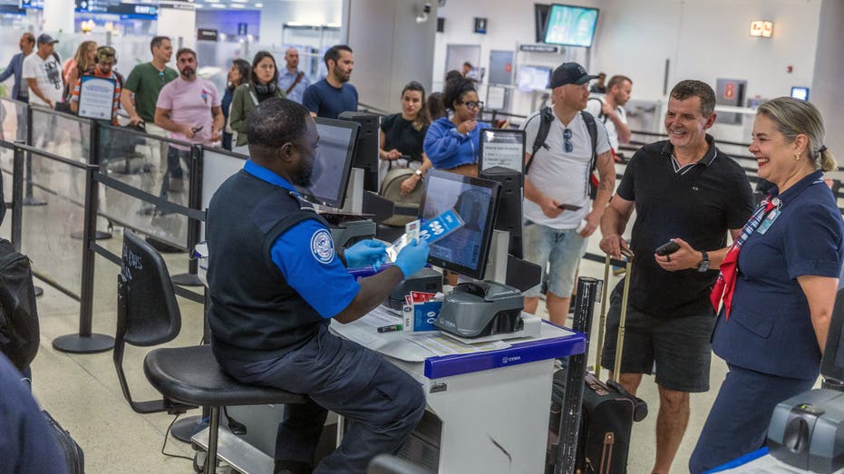 يقوم عملاء TSA بالتحقق من هويات الركاب عند نقطة تفتيش في مطار ميامي الدولي حيث أعلنت إدارة أمن النقل (TSA) عن التنفيذ الوشيك لتدابير إنفاذ الهوية الحقيقية عند نقاط تفتيش TSA على مستوى البلاد، الأربعاء 07 مايو 2025.