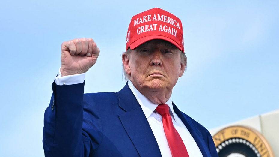 الرئيس دونالد ترامب يضخ قبضة يده أثناء صعوده على متن طائرة الرئاسة