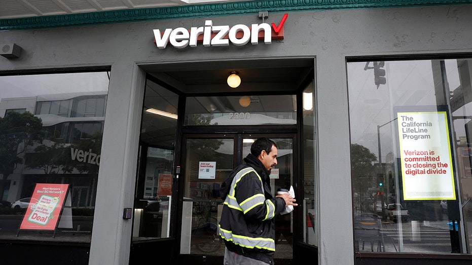 رجل يسير أمام متجر فيريزون