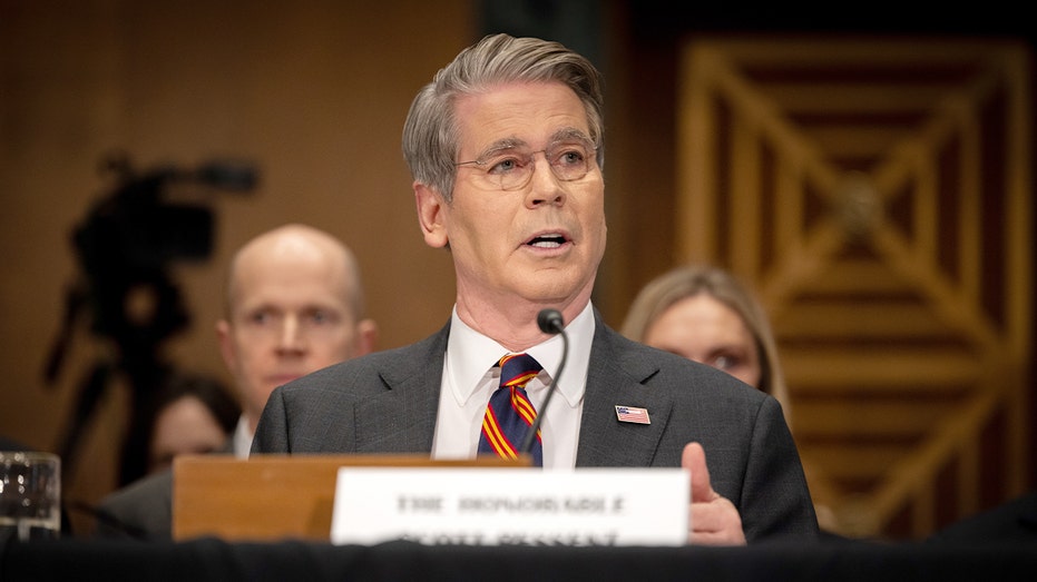 يجلس سكوت بيسنت على طاولة الاستماع ويتحدث عبر الميكروفون أمام المشرعين.