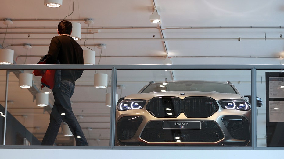 ينظر العميل إلى سيارة بي إم دبليو رمادية اللون