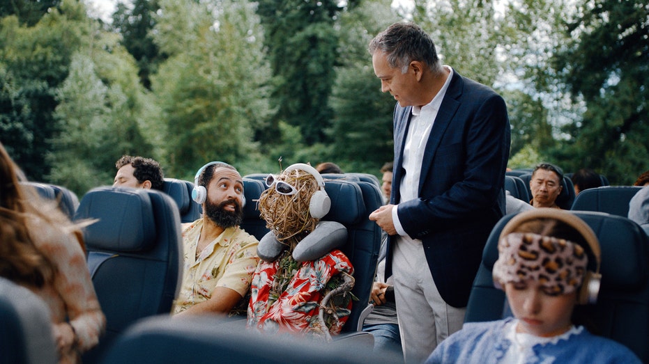 رجل يسأل رجلاً آخر إذا كان يمكنه الجلوس على الكرسي المجاور له