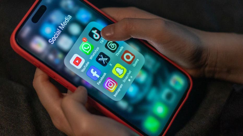 طفل ينظر إلى هاتف به تطبيقات الوسائط الاجتماعية