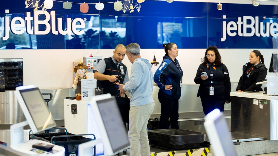 أحد الركاب يقف مع أمتعته في كشك الخدمة الذاتية في منطقة محطة JetBlue في مطار فيلادلفيا الدولي.