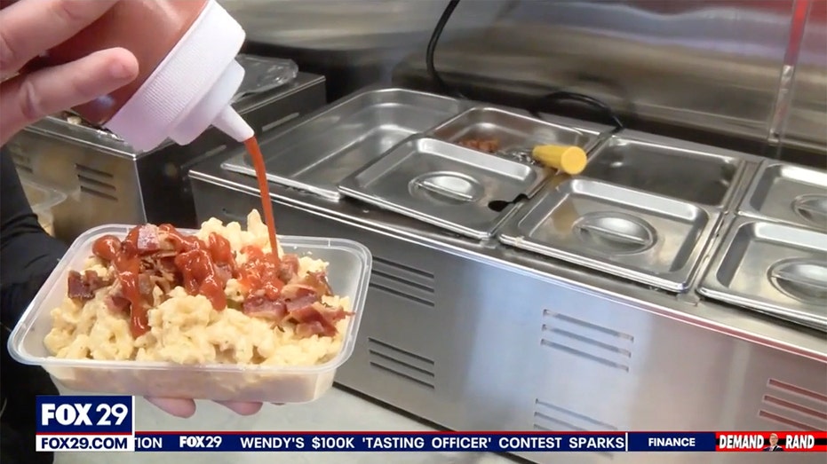 شخص يسكب الصلصة على الطبق.