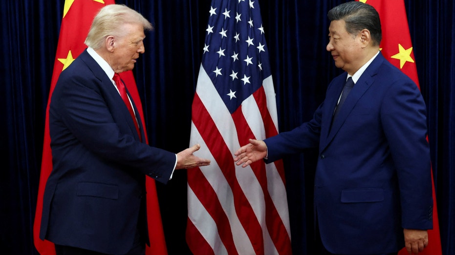 الرئيس دونالد ترامب يصافح الرئيس الصيني شي جين بينغ أمام العلمين الأمريكي والصيني.